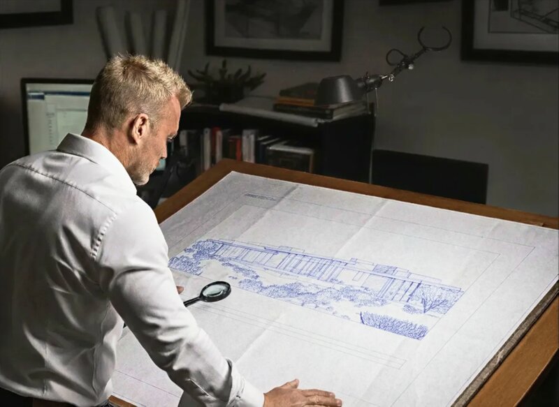 JA Development Group founder reviewing architectural blueprints at his desk