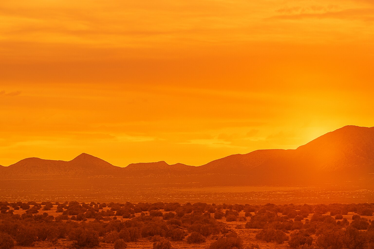 Orange sunset over desert mountains in New Mexico high desert